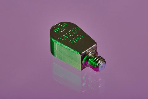 A close up shot of an A/127 accelerometer in a purple background