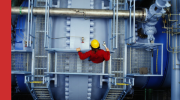Shows Beran engineer on power station looking down over machinery