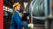 Power station engineer standing next to a turbine
