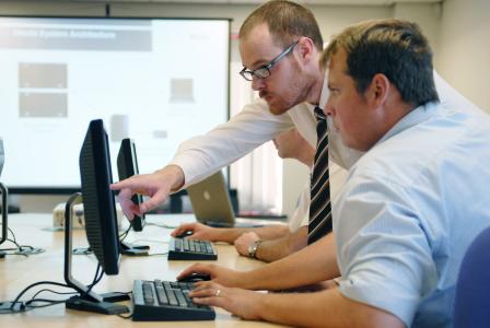 Two people in office looking at computer screen