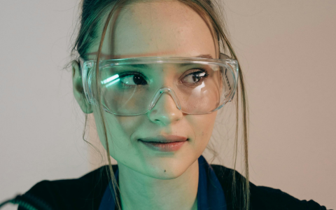 Young woman apprentice wearing safety glasses in an engineering environment
