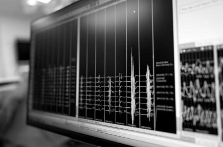 Close-up of a monitor displaying multi-channel vibration data, in black and white.
