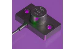 A close up shot of an A/52 accelerometer in a purple background