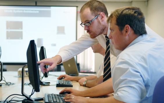 Two people in office looking at computer screen