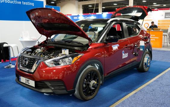 A red test car with bonnet up showing engine