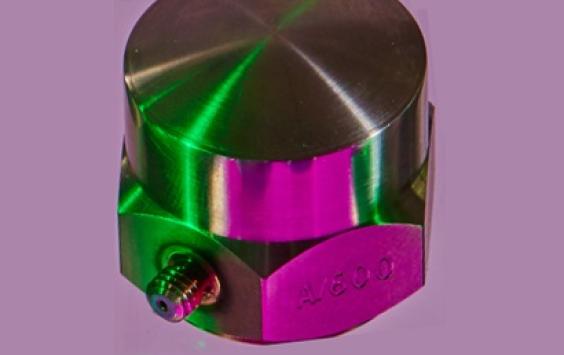 A close up shot of an A/1600 accelerometer in a purple background