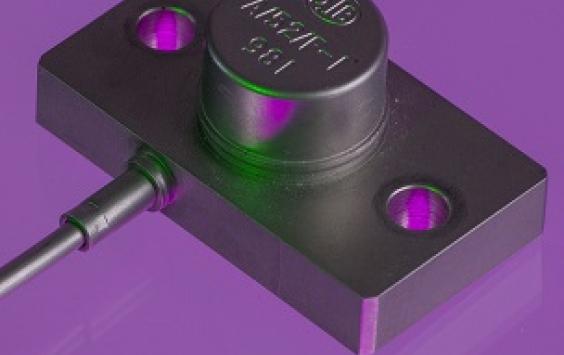 A close up shot of an A/52 accelerometer in a purple background