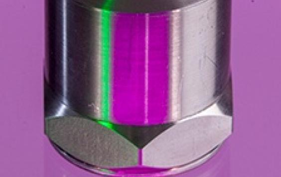 A close up shot of an A/1800 accelerometer in a purple background