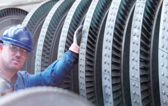 Two male engineers working on a power station turbine