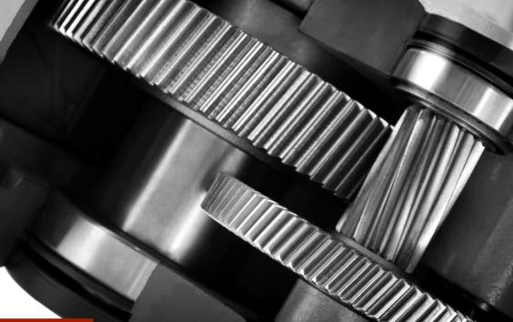 Close-up of meshing gears and a bearing inside a gearbox, in black and white.