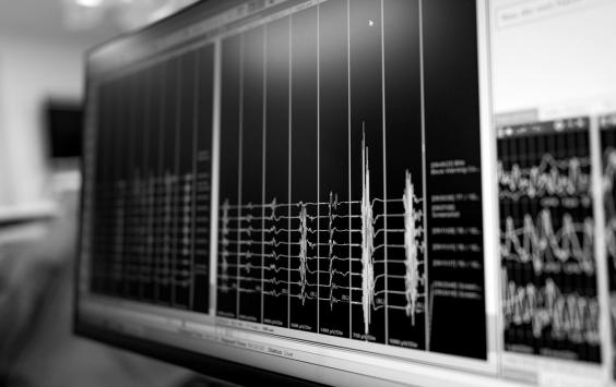 Close-up of a monitor displaying multi-channel vibration data, in black and white.