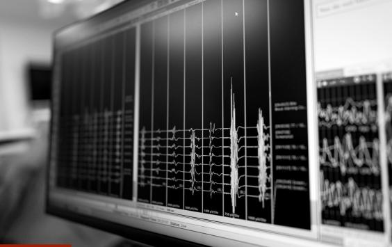 Close-up of a monitor displaying multi-channel vibration data, in black and white.