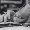 Image shows close up of male hand with calculator and pen